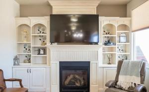 a living room with a fireplace with a flat screen tv at Fossil Crest Retreat in Vernal
