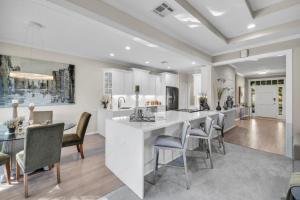 a kitchen and dining room with a large white island at The Tulsacation on Oxford in Tulsa