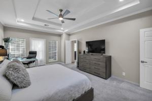 a bedroom with a bed and a flat screen tv at The Tulsacation on Oxford in Tulsa