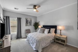 a bedroom with a bed and a ceiling fan at The Tulsacation on Oxford in Tulsa