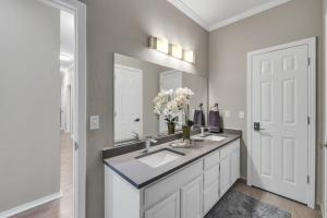 a bathroom with a sink and a large mirror at The Tulsacation on Oxford in Tulsa +14 photos