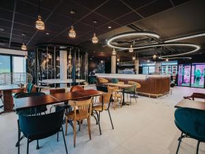 a restaurant with tables and chairs and a bar at Greet Hotel Brest Aéroport in Guipavas