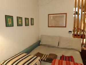 a bed in a room with some pictures on the wall at Propaganda Room in Albano Laziale