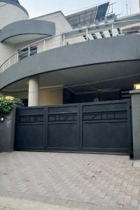 a house with a large gate in front of a building at Luxury Private Room Canal Rd Near Galleria in Faisalabad