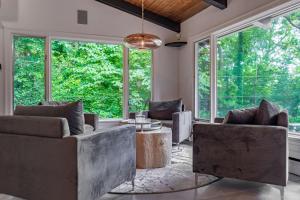 a living room with couches and a table and windows at Chic Modern Glam in Rockford
