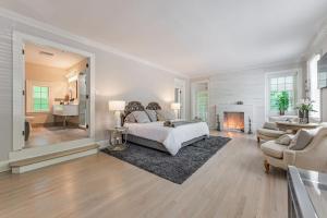 a bedroom with a bed and a living room with a fireplace at Chic Modern Glam in Rockford