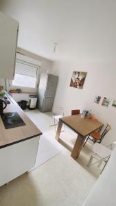 a kitchen with a table and a refrigerator in a room at Nancy centre bienvenue, chambre chez l'habitant in Nancy
