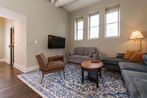 a living room with a couch and a tv at Downtown Luxe 2BR Loft Apt | Prime Location | Sleeps 10 in Milwaukee