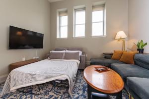 a living room with a couch and a table at Downtown Luxe 2BR Loft Apt | Prime Location | Sleeps 10 in Milwaukee