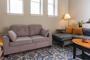 a living room with a couch and a chair at Downtown Luxe 2BR Loft Apt | Prime Location | Sleeps 10 in Milwaukee