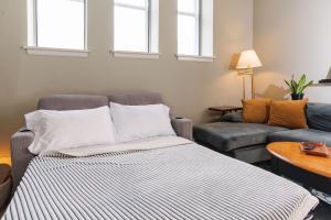 a living room with a couch and a couch and windows at Downtown Luxe 2BR Loft Apt | Prime Location | Sleeps 10 in Milwaukee +17 photos