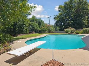 a swimming pool with a bench in front of it at The Tulsacation 2 in Tulsa