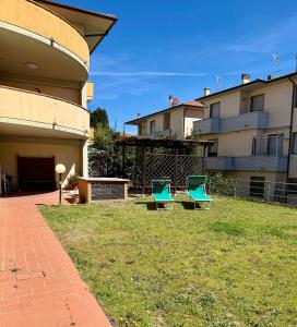 two blue chairs in a yard next to a building at Casa Serena in Donoratico