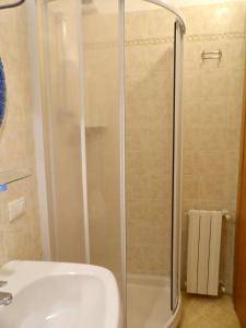 a shower with a glass door next to a sink at Casa Serena in Donoratico
