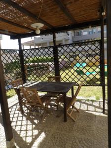 a picnic table and two chairs under a pergola at Casa Serena in Donoratico +12 photos