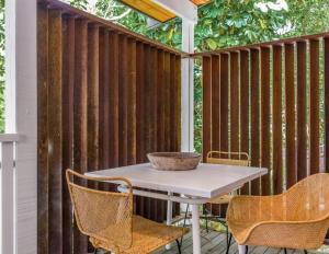 a table and chairs on a patio with a fence at Sanctuary Spaces - Sunset Bungalow 101 in Byron Bay