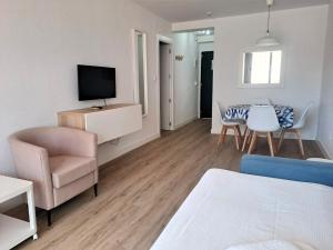 a living room with a couch a chair and a television at Apartamentos Buensol in Torremolinos