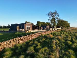 a row of houses in a field next to a fence at Scald Law in Penicuik +17 photos