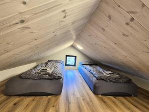 two beds in a attic room with wooden ceilings at Northern Lights Cabin - Syribr in Grímsnes og Grafningshreppur