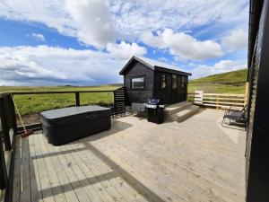 a black tiny house on a wooden deck at Northern Lights Cabin - Syribr in Grímsnes og Grafningshreppur