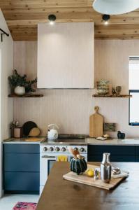 a kitchen with blue cabinets and a white stove at Camp Cold Springs in Concan