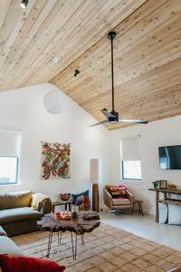 a living room with a wooden ceiling with a couch and a table at Camp Cold Springs in Concan