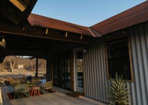 a patio with chairs and tables and a roof at Camp Cold Springs in Concan
