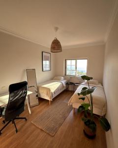a bedroom with a bed and a desk and a chair at The Salty Nap in Ericeira
