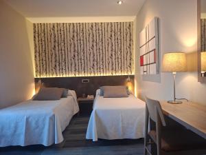 ein Hotelzimmer mit zwei Betten und einem Fenster in der Unterkunft Hotel Oriente in Teruel