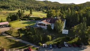 an aerial view of a house with cars parked in a parking lot at Gite de la Baie Hatée in Bic