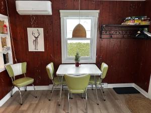 a dining room with a white table and chairs at Chalet memphrémagog - 203 in Magog-Orford