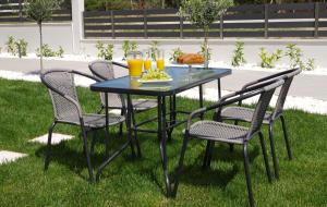 a table with four chairs and orange juice at Sithonian Sunset Luxury Apartments in Skála Nikíta