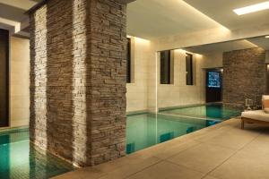 a swimming pool in a hotel with a brick wall at Maison Bauchart in Paris