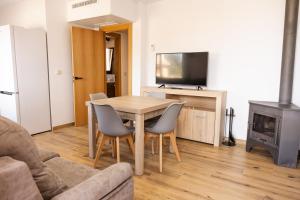 a living room with a table and chairs and a television at Apartamentos 7 Puentes Sierra Cazorla Las 5 casas iguales in Burunchel