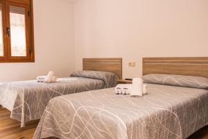 a room with three beds with white sheets and a window at Apartamentos 7 Puentes Sierra Cazorla Las 5 casas iguales in Burunchel +80 photos