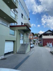 a apartment building with stairs and a parking lot at Stan na dan Alisa Cazin in Cazin
