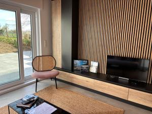 a living room with a flat screen tv and a chair at NEW - Mullerthal Basecamp - Sleeps 6 in Beaufort