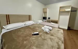 a bedroom with a large bed with two pillows at Pousada Cores De Outono in Canela