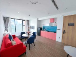 a living room with a red couch and a table at Flamingo Hai Tien Beach Resort in Thanh Hóa