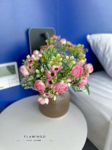 a vase filled with pink flowers sitting on a table at Flamingo Hai Tien Beach Resort in Thanh Hóa +13 photos