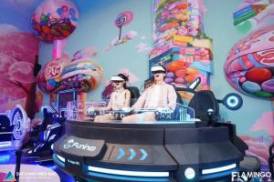 two people sitting on a roller coaster in a room with balloons at Flamingo Hai Tien Beach Resort in Thanh Hóa