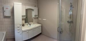 a white bathroom with a sink and a shower at Dispen feriehus in Stryn