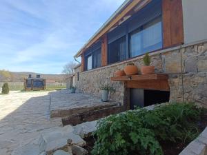 a stone house with a stone wall and a patio at MORLAK - Guest House - Restaurant - Gated parking in Polača