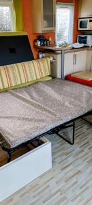 a bed in a room with a kitchen at Mobile Home privé dans camping n 69 in Port-Bail-sur-Mer