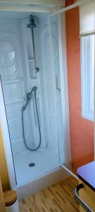 a bathroom with a shower with a glass door at Mobile Home privé dans camping n 69 in Port-Bail-sur-Mer