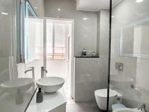 a white bathroom with two sinks and a toilet at Edion Center Apartment in Shkodër +24 photos