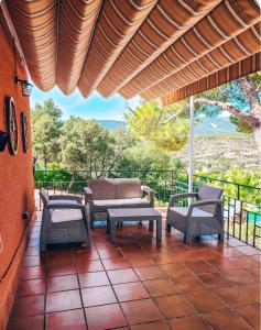 a patio with chairs and tables and a roof at Casa Terra in Hontanar