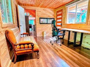 a room with a bench and a chair and a desk at Cabañas Alto del Bosque in Coñaripe