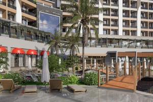 a courtyard with chairs and umbrellas in front of a building at Almaris Resort in Alanya