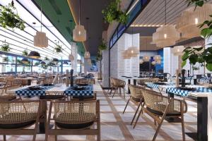 a restaurant with tables and chairs and chandeliers at Almaris Resort in Alanya